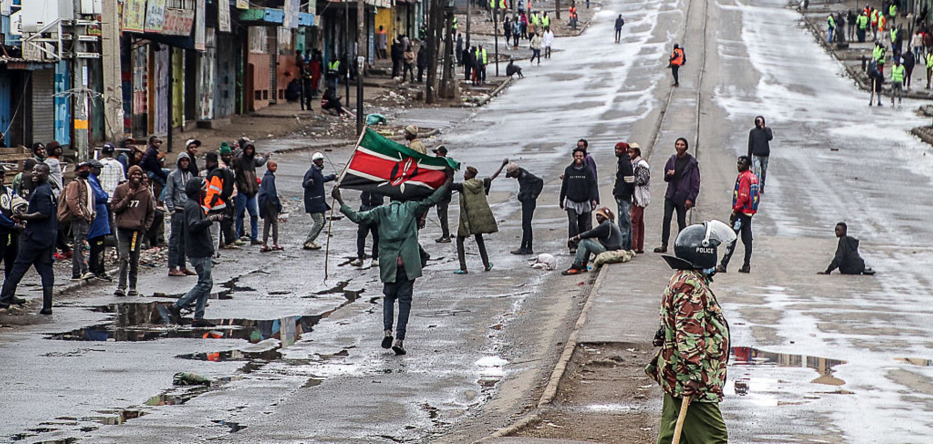 Young Kenyan protesters holding signs, flags, or smartphones during demonstrations